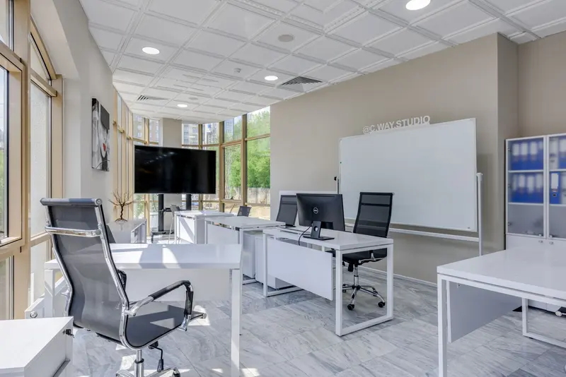 Bright open office with white desks, task chairs and large windows